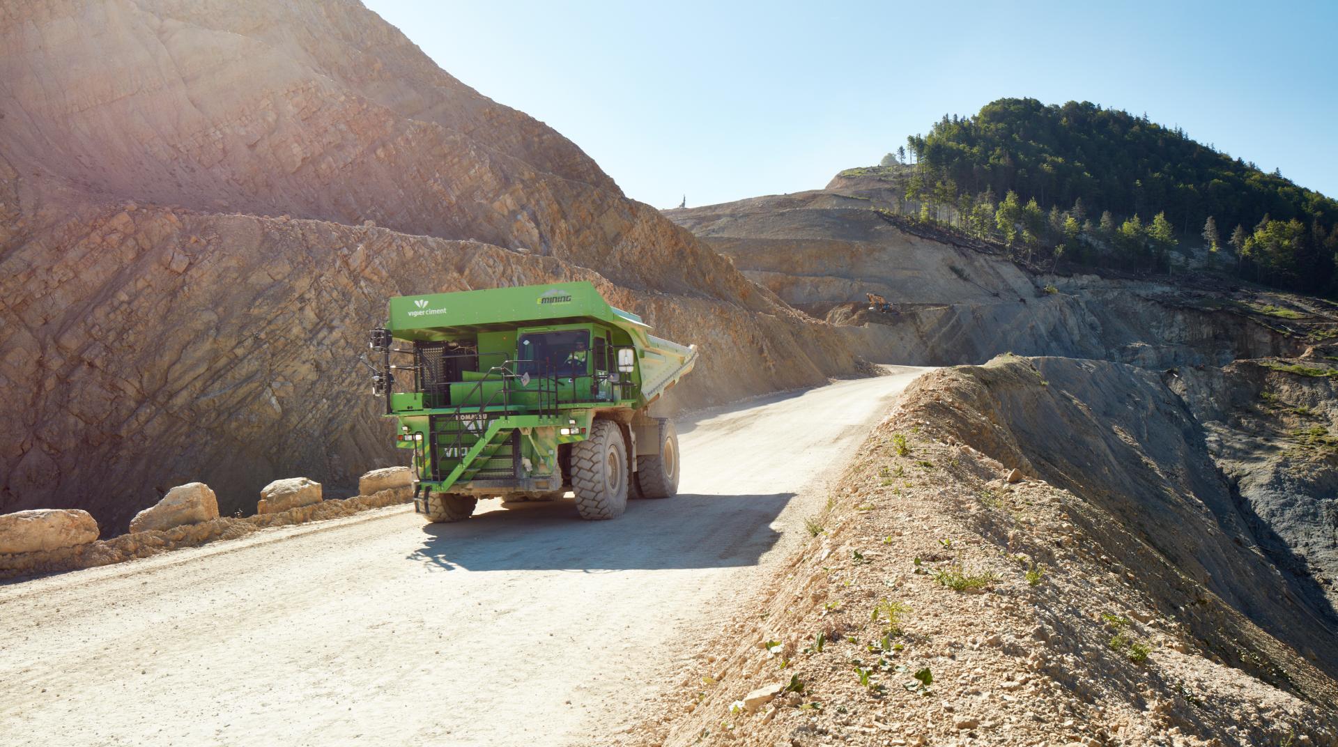 Der grüne E-Dumper von Vigier Ciment fährt durch die Kiesgrube